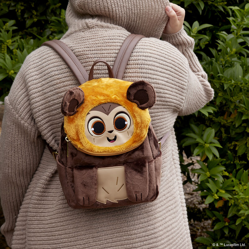 Person outside wearing a beige cardigan wearing the Wicket plush mini backpack 
